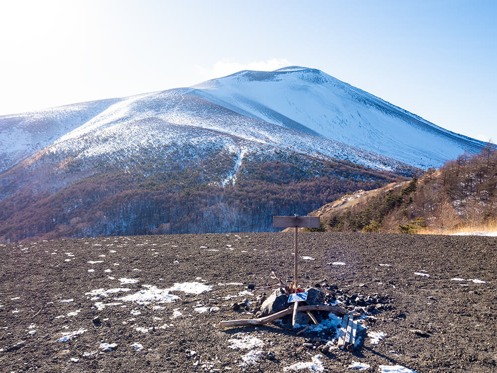 小浅間山山頂から間近に望む、雄大な雪の浅間山と冬の青空