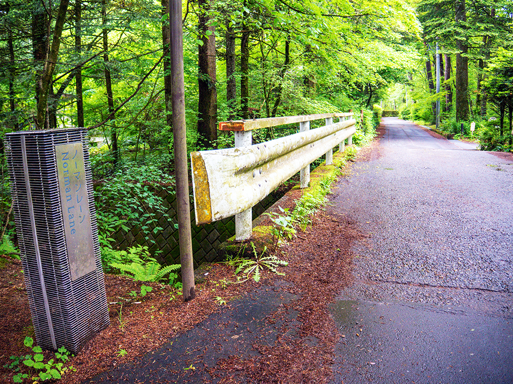 雨上がりの旧軽井沢。しっとりと濡れた緑の木々に囲まれたノーマンレーンの入り口の看板